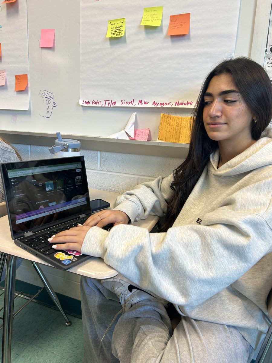 Junior Hana Ghalib searches for her favorite song during independent work time in AP Seminar.