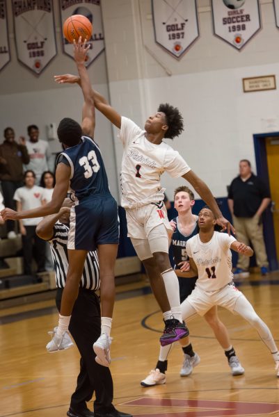 Senior Jaiden Aze tips off at the boys varsity basketball home opener against Magruder. Wootton beat Magruder 59-58.