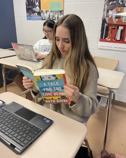 Senior Julia Messing catches up on her assigned reading for the AP Lit book, A Tale for the Time Being, during class. Compared to other books we read this year I think its much more interesting, Messing said.