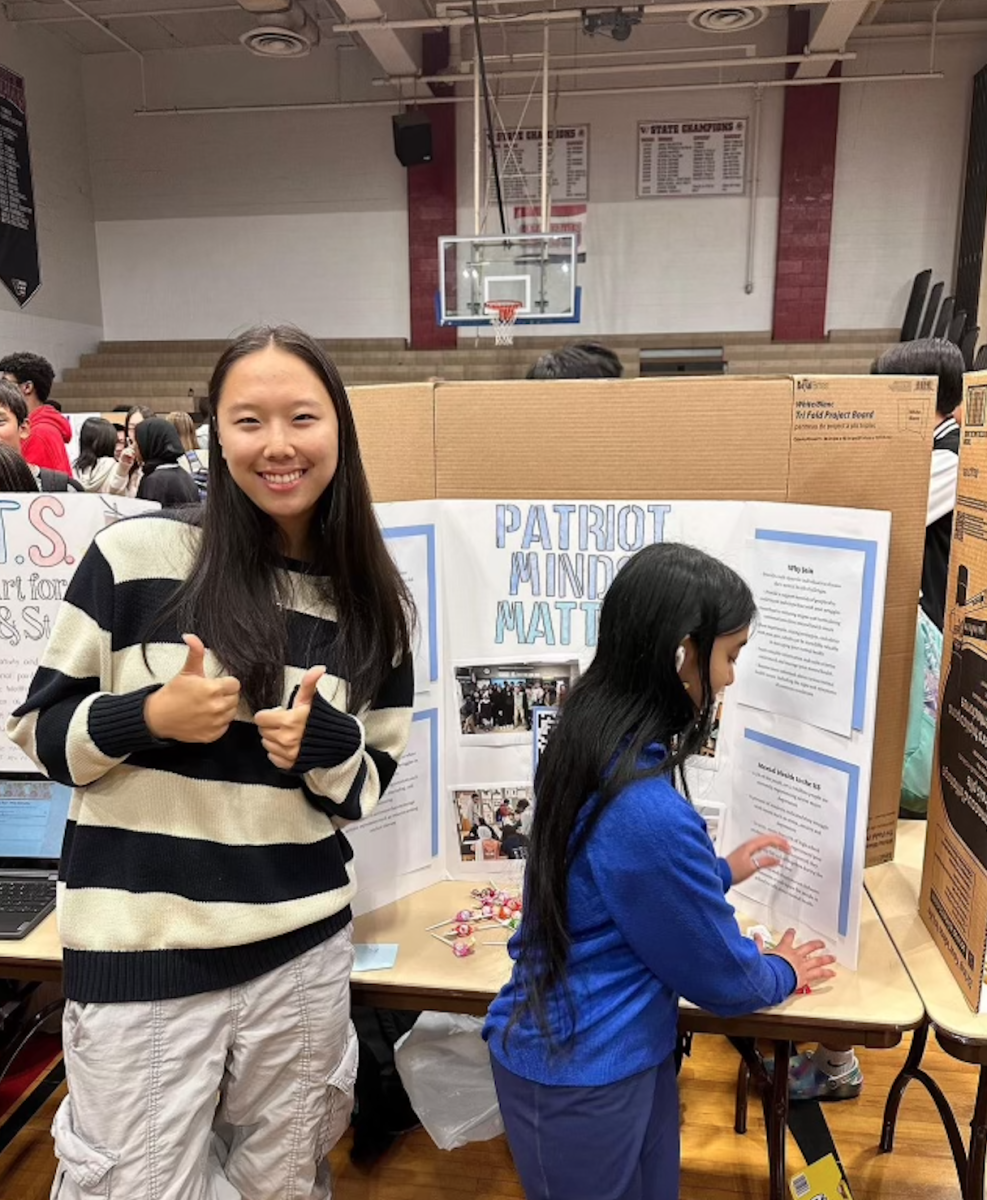 Junior Rebecca Gao runs the Patriot Minds Matter booth at the club fair on Sept. 26. The club fair offers over 100 clubs to students, encouraging students to sign up using candy and other free giveaways.