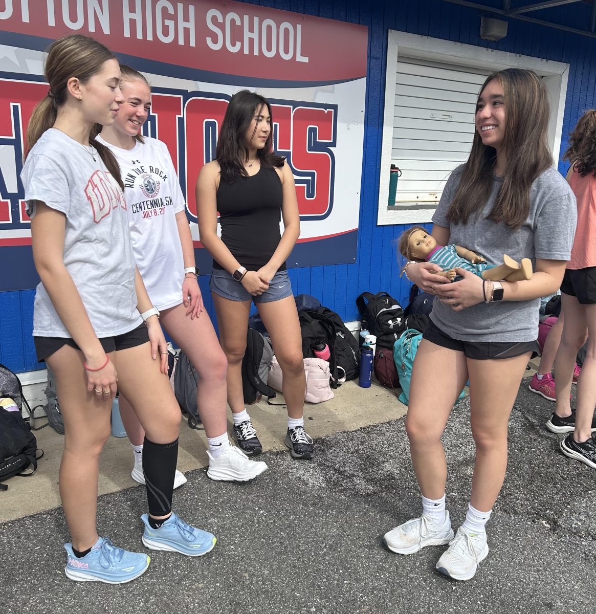 Sophomore Becca Hwang talks to junior Eva Veizis and sophomores Charlotte Hoffman and Olivia O’Connor while taking care of her baby before track practice on Mar. 13. “The child always has to be watched; even when you are going to the bathroom during class you need to find someone to watch the child,” Hwang said.