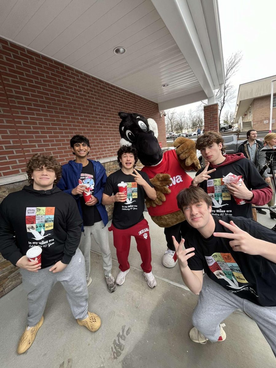 Seniors Jake Kelley, Sebastian Valdivia, Aamruth Adarsh, Everett Field, junior Connor Jackson, and mascot Walley Goose wear the shirts given to them by Wawa and drink sodas in front of the new Wawa on opening day.