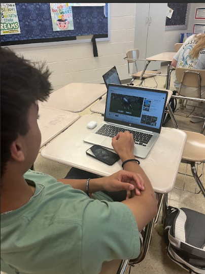 Sophomore Aadi Chaudhari watches a lacrosse game instead of doing his work in health class.