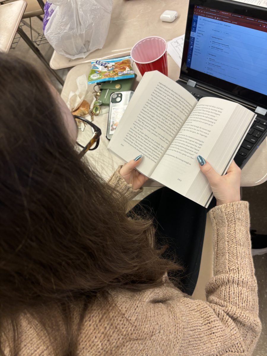 Senior Jordyn Cottone reads the third book in the Divergent series, Allegiant, during free time in her first-period ASL class. I love how powerful Tris is throughout the series, Cottone said.