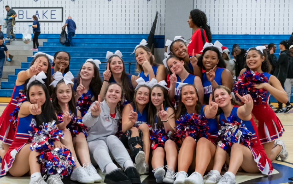 Senior Ellie Mollica (bottom center) celebrates boys basketball winning the regional championships against Blake on Mar. 5 with the cheerleading team. Mollica reflects on her time with the team as she begins looking toward graduation.