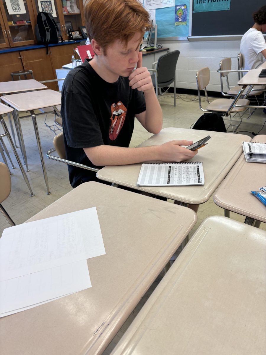 Sophomore James Colvin scrolls on phone instead of doing classwork. Throughout the fourth quarter but especially now with only about two weeks left in school, I find it really hard to get work done instead of doing a different activity outside of school, Colvin said.