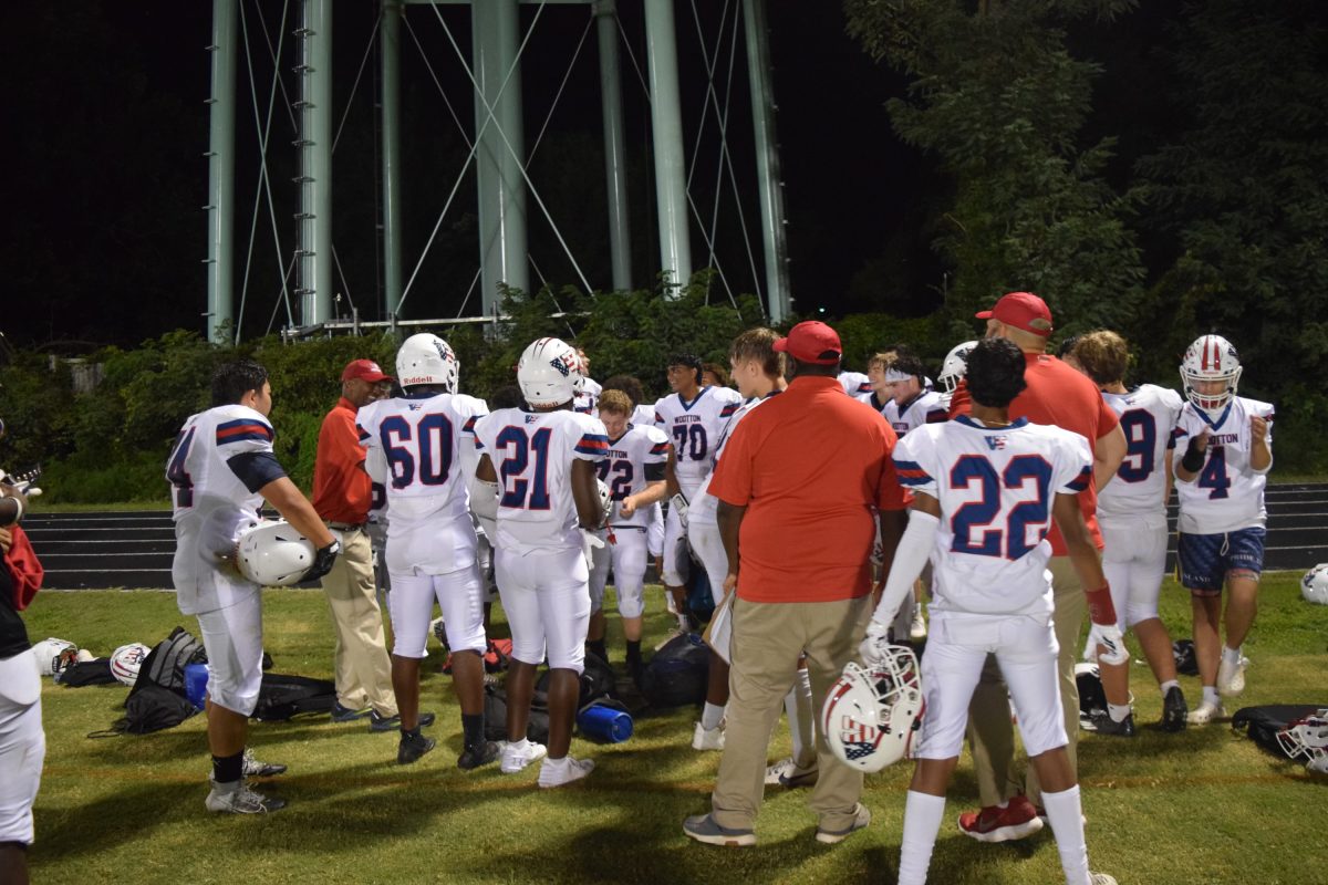 The varsity football team huddles after defeating Poolesville 43-0 in a shutout. "The team looked great and it's a good momentum boost for the rest of the season," senior Thomas Mehler said.