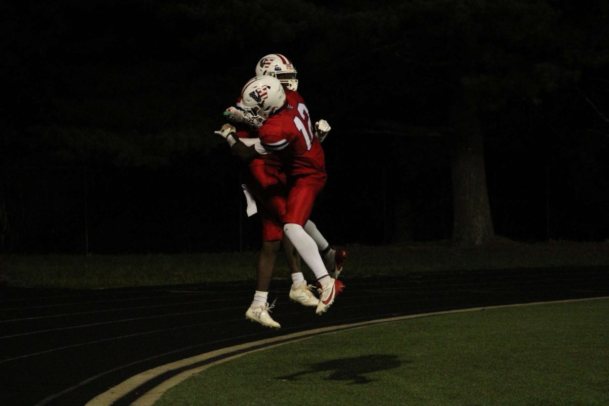 Juniors Bryan Ngouzo and Ashton Ingram celebrate a touchdown by Ngouzo during the first home football game against the Rockville Rams on Sept.13. This is an example of the sports photojournalism of Keon Gray.