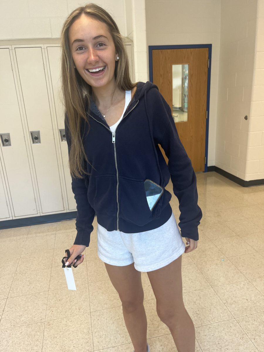 Junior Peyton Higgins shoves her phone into the small pocket in her sweatshirt while walking in the hallway on Sept. 6. “I have some clothes with pockets in them, some don’t,” Higgins said.