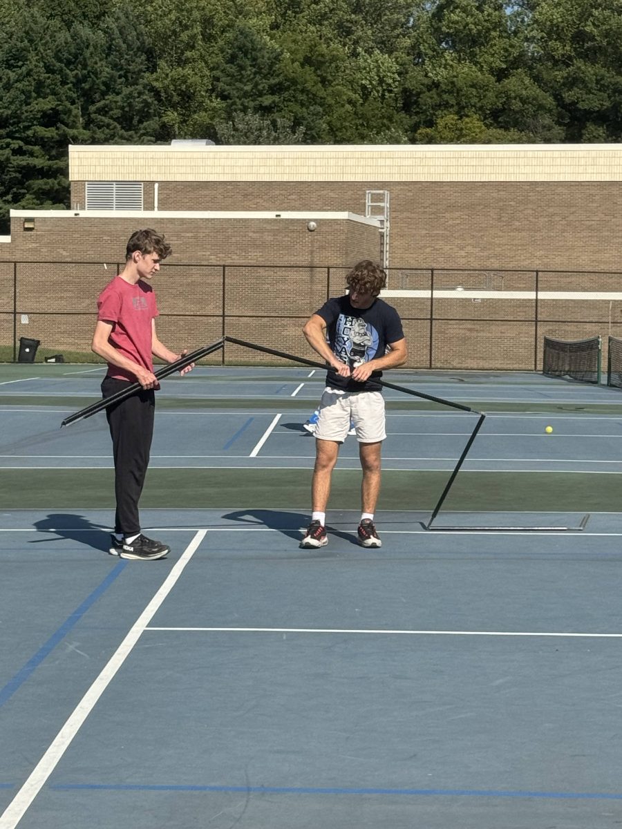 Freshman Mason Owen and senior Travis Sklar clean up the nets after practice on Sept. 9. The MCPS Pickleball League launched its first year and is a hit among students. "The team has allowed me to spend time with new people and friends," Sklar said.