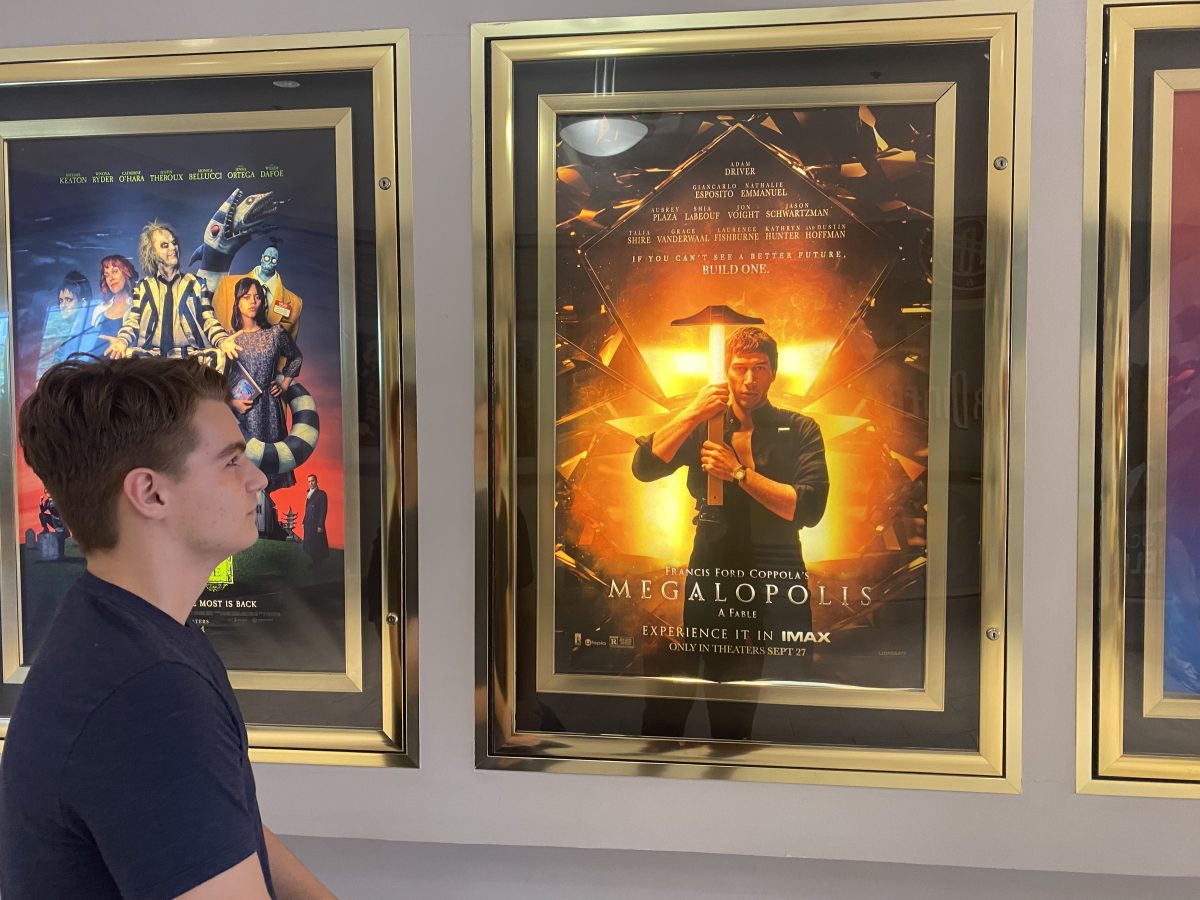 Senior Brandon Bartee stands in front of the poster for Francis Ford Coppola's 23rd film, "Megalopolis" outside of AMC theaters on Sept 28. "Any attempt to portray a message or make a grand critique of the world fell very far short, a waste of two hours," Bartee said.