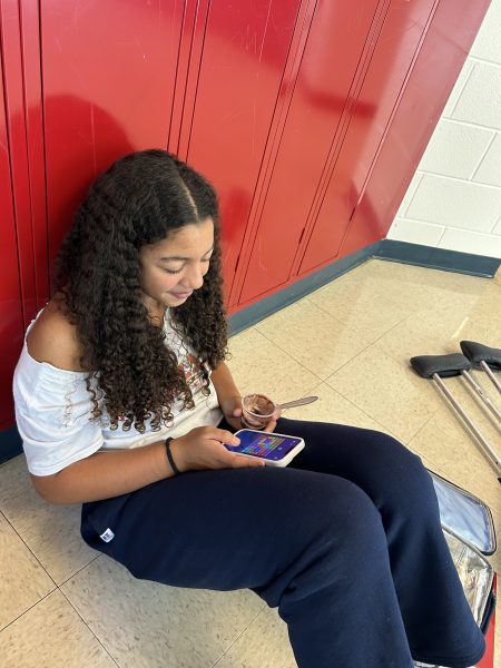 Sophomore Malia Bellamy plays games on her phone while eating lunch. Bellamy said that a school-wide phone ban would not be necessary because there are already strict rules about students using their phones in classrooms so taking away the right to use it during free times is unfair. “Lunch time is the only break we have in school so it’s the best time to relax on your phones,” Bellamy said.