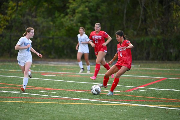 Junior Megan Lomotan takes on a Whitman defender on Monday, Oct. 14, senior night. Senior Bianca Diamond, number 21, scored in the last home game. "I'm super excited for playoffs because I think we have a really strong team," Diamond said.