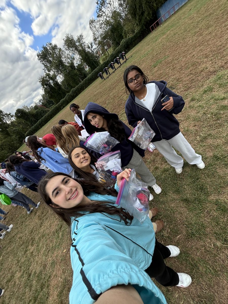 Seniors Daniella Riba, Mia Silbert, Inayat Thukral and Saanvi Gadila participate in the tie-dye event Wednesday, Oct. 16, on the portable field. They put their finished shirt in a bag to wear to the homecoming football game that Friday.