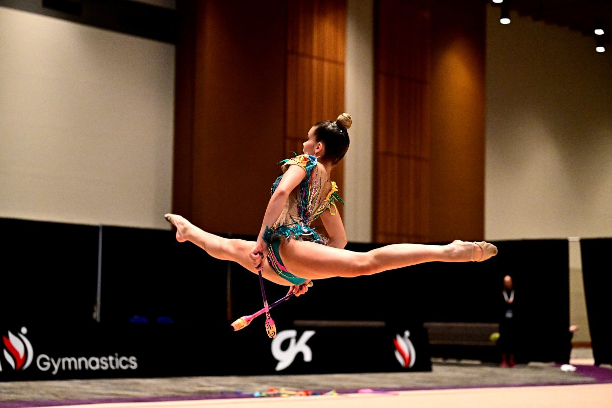 Former competitive gymnast, gymnastics coach and poms dancer Anna Illarionov flies through the air during a routine. Illarionov earned a medal at each of the Junior Olympics and nationals competitions she competed in during her career.