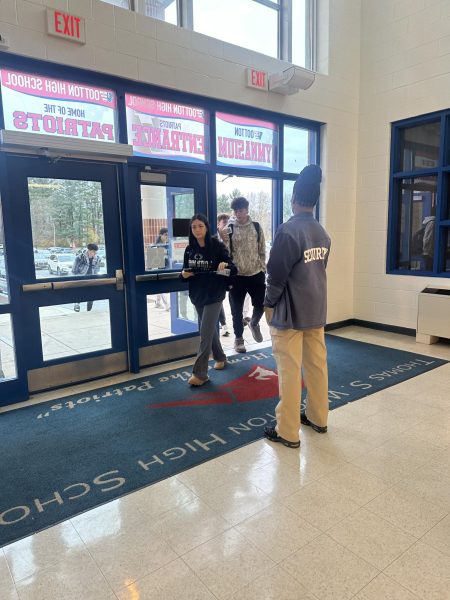 Students enter through the lower gym doorways while showing their IDs to security as they make their way inside.