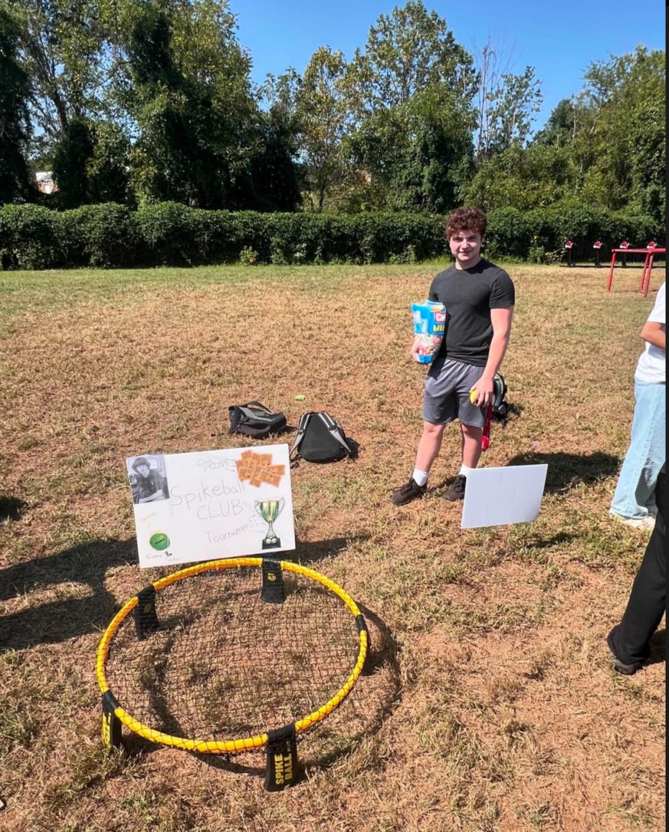 Spikeball Club President Brandon Luxenberg sets up a booth for the Club Expo in the back field on Sept. 20.