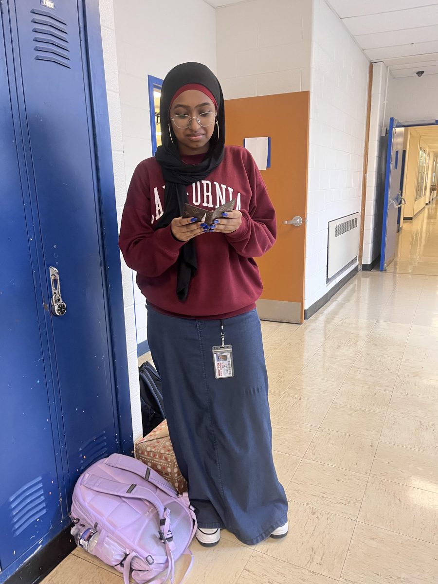 Junior Ginana Ahmed wants to make an online purchase so she gets out her wallet to see which cards she has and will use.