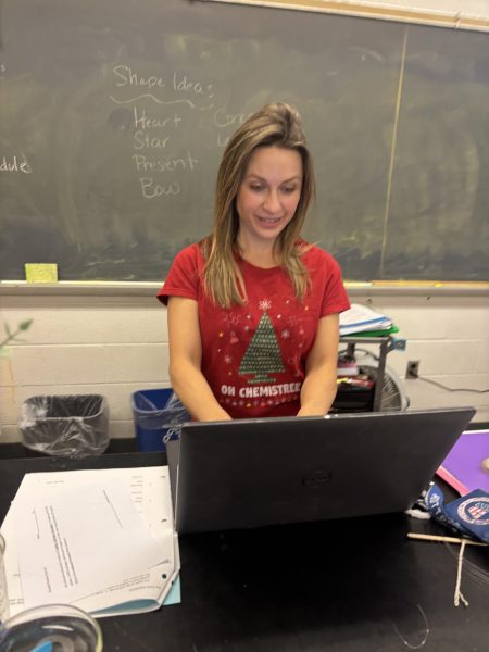 Science teacher Kristen Daugherity works to connect her computer to the smartboard for her seventh-period honors chemistry class on Thursday, Dec. 19.