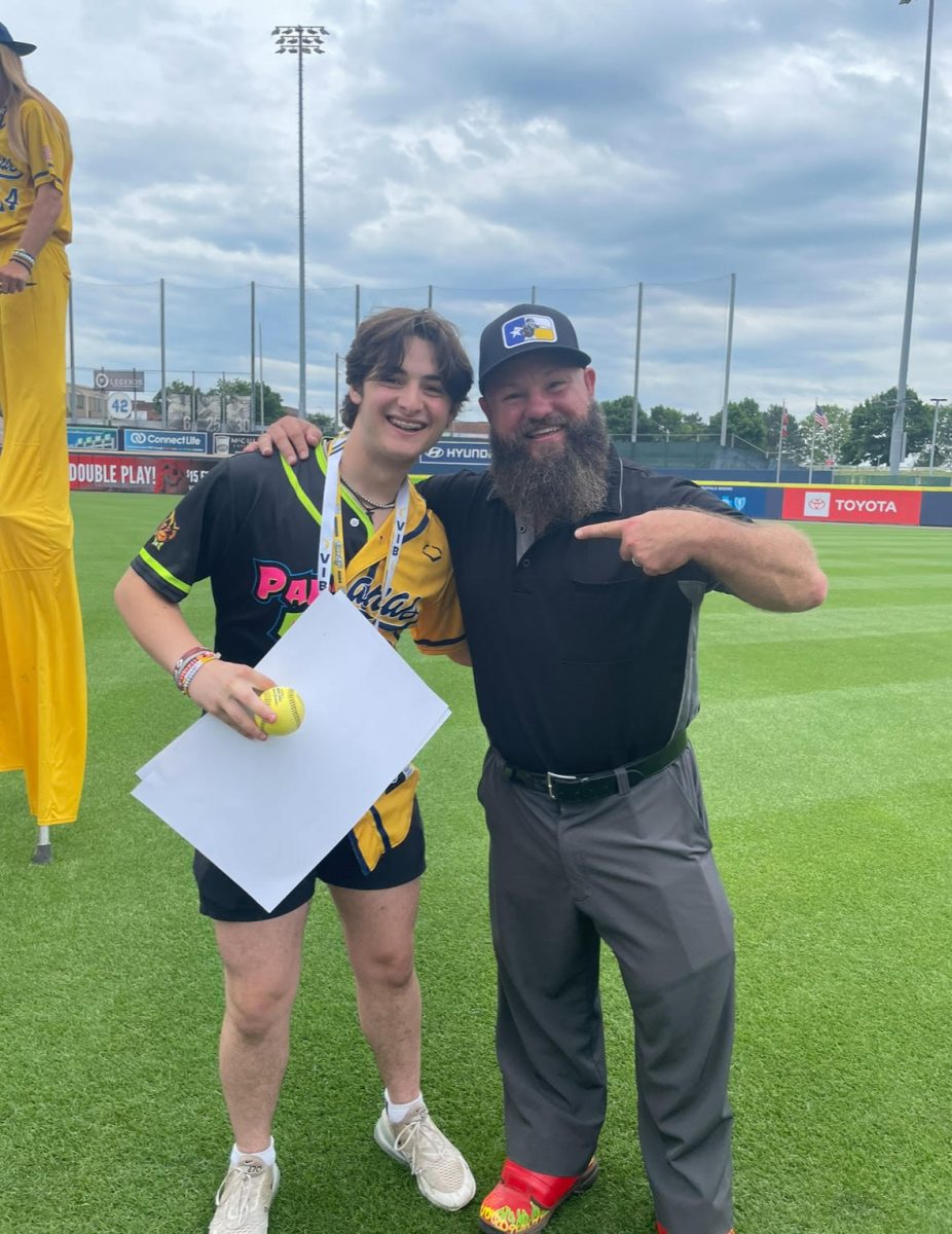 The Savannah Bananas umpire celebrates with junior Tyler Mollica at the VIB meet and greet at Sahlen Field on July 5.