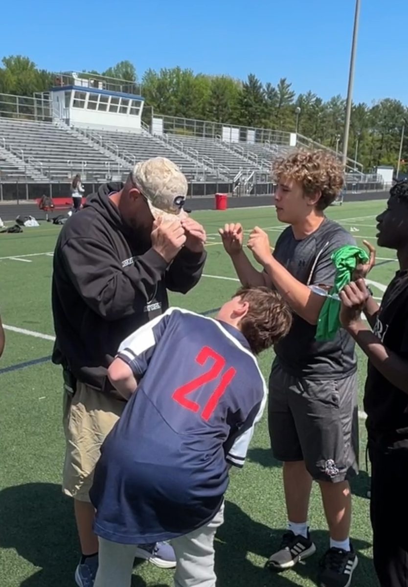 Gym teacher James Long referees a soccer game between the eighth period soccer class and the eighth period flag football class. Senior Thomas Mehler and junior Luca Phillips protest the penalty kick against their team.