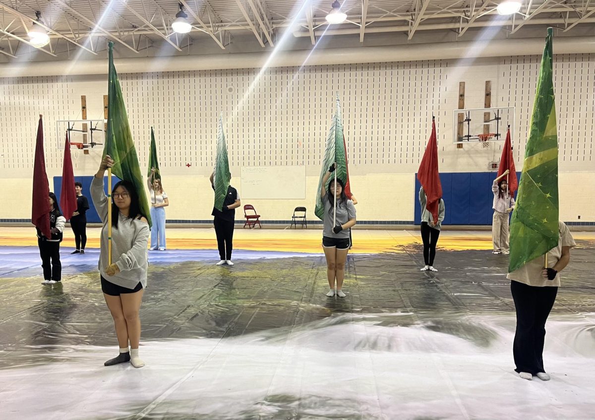 The indoor color guard rehearses in the lower gym on Monday, Dec. 9. "I feel like the guard, as a whole, is improving significantly in their fundamental technique, especially on flag. I'm excited to see our training and hard work pay off," color guard co-captain Summer Yao said.