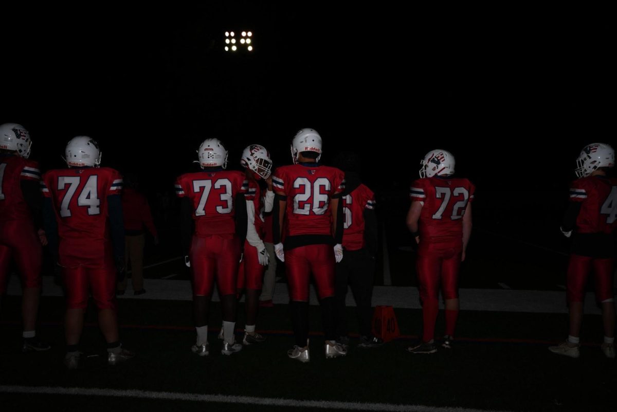 Sophomore Jeremiah Ofori (number 73) and his teammates get ready for a football game.