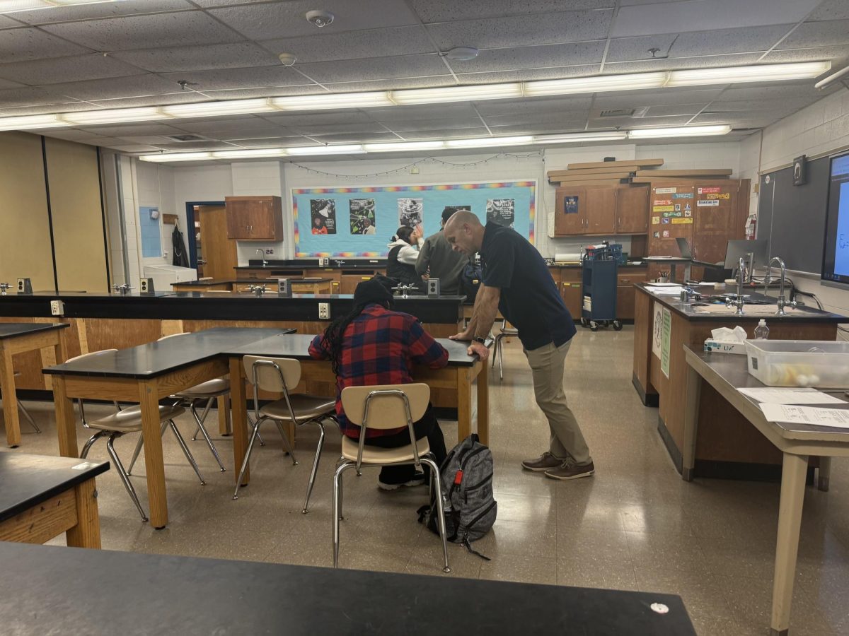 Physics teacher Michael Thompson helps a student on an assignment during advisory on Thursday, Dec.19.