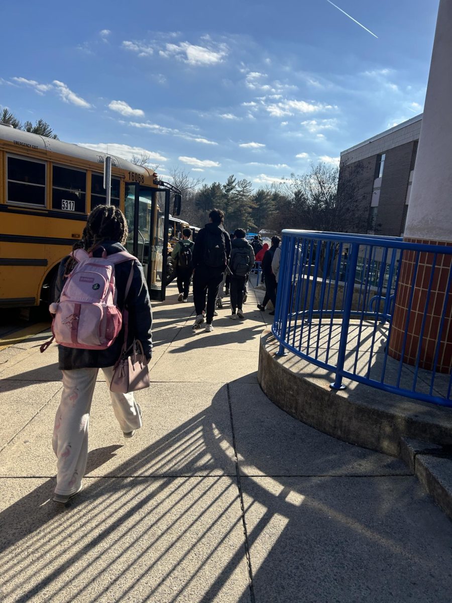 Students walk alongside buses as they exit the school. Sometimes they walk between the buses to the other side of the street - a main factor in the decision to add a bus loop.