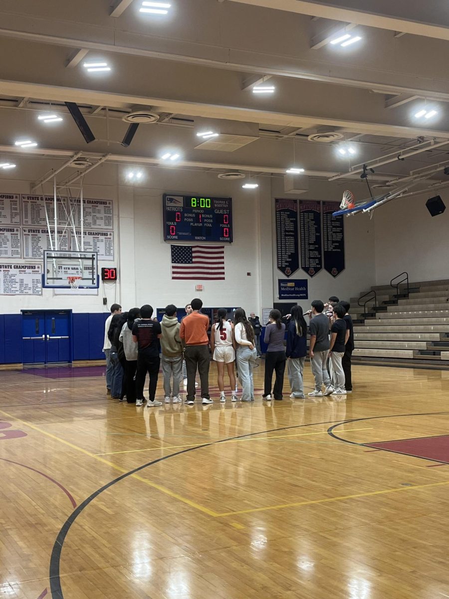 The Acatonics perform the national anthem live at the girls' basketball game on Jan. 10. A capella teacher Keith Schwartz helps them stay on key.