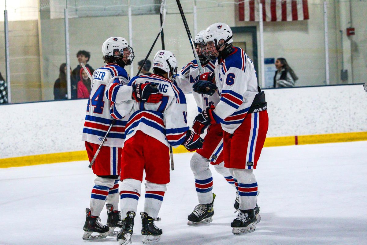 Junior Justin Heller, sophomore Nathan Geeng, senior Samuel Hosier and their teammate huddle during a varsity hockey game against Sherwood on Dec. 6. The team lost this game 5-5, but are not letting that define their season. Despite another loss in their most recent game against Walter Johnson, they anticipate going far in the playoffs this year. “The season has been going decent so far, but I think the most recent game could have gone a lot better,”  Heller said.