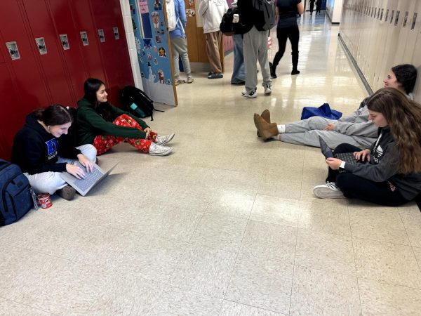 Juniors Beliz Kuter, Simrik Mahata, Shayna Kreiser and Emma Illig work on homework in the hallway during advisory on Friday Dec. 20. "I like having advisory but I would prefer it if we had it with lunch as well so we have more time to do assignments instead of having a 20 minute block," Kuter said.