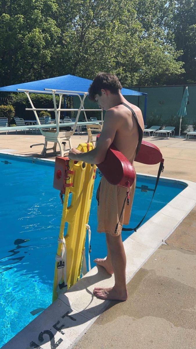 Senior Alex Balian practices saving techniques poolside at Fallsmead Homes Pool last summer.