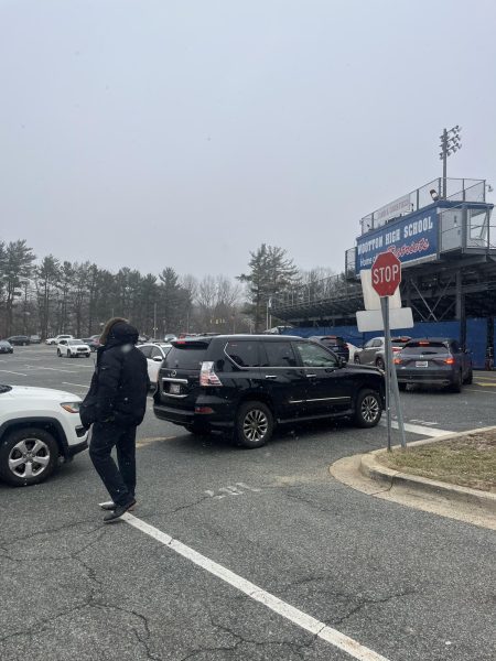 Acting Principal Dr. Joseph Bostic Jr. helps direct afternoon traffic in the parking lot. Despite the help of the security team and other staff, the parking lot rules are often ignored. "People can't get out that are trying to get out, and parents don't seem to care," social studies teacher Christopher McTamany said.