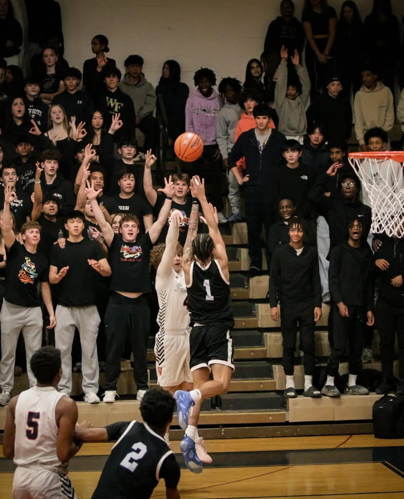 Varsity boys' basketball faces off against Hubert Blake on Feb. 21, the student section showing out for the theme and supporting their team.