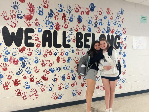 Class of 2023 graduates and former Best Buddies Co-Presidents Josie Starr and Dani London  proudly show off the completed version of their original mural. “It’s still really special to me. Best Buddies has shaped me to learn what I’m passionate about,” Starr said.