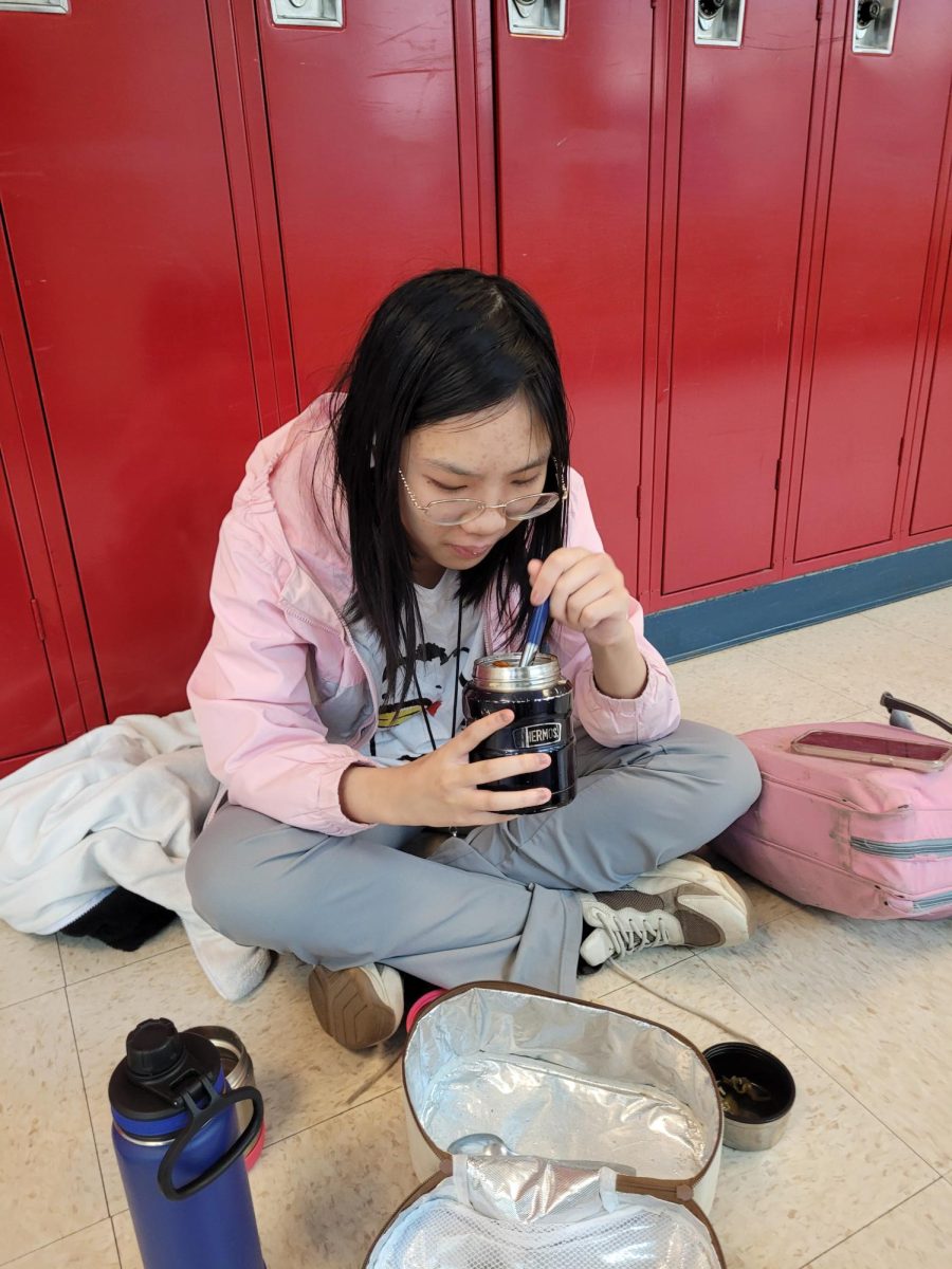 Junior Ellen Ming eats lunch in the hallway between rooms 149 and 151 on Mar. 7. Ming chooses to eat lunch with her friends due to the convenience it offers combined with a lack of disturbances.