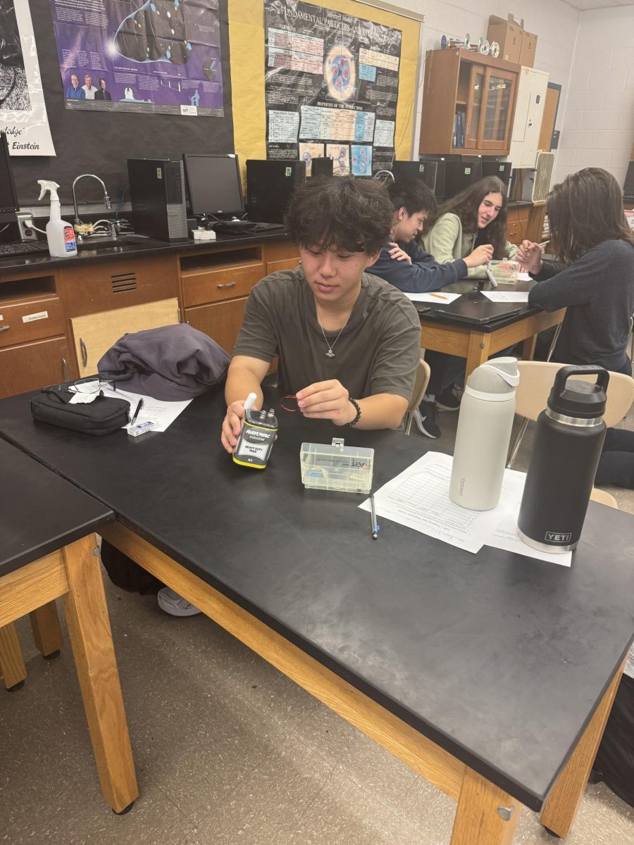 Senior Justin Huang plays with a battery, magnet and wire kit in his AP Physics C: Electricity and Magnetism lab period. "This class forces you to think more conceptually rather than algebraically. I had to break things down and see things in a more simple way," Huang said.