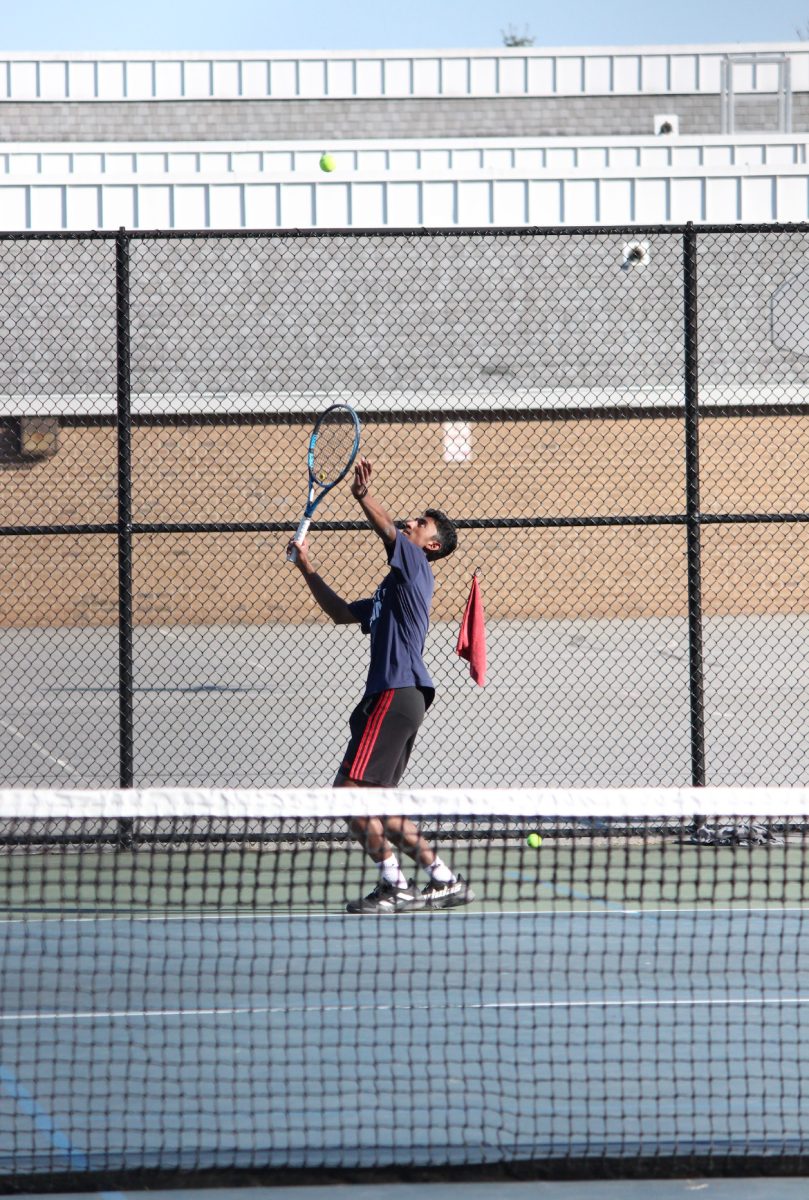 Junior Vikram Reddy serves in their scrimmage against Landon on Mar. 11.