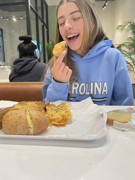 On Friday, Feb. 28, sophomore Manuella Poggio takes a bite of a sausage rolled in garlic bread in the brand new restaurant Tous Les Jours Cafe. "That pastry was the second best behind the cream cheese garlic bread,"  Poggio said.