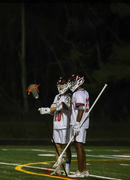 Junior defensemen Kwan Lee and Jay Vardhan discuss strategy against the Blake varsity boys' lacrosse team on Apr. 4. The Patriots lost 15-5.