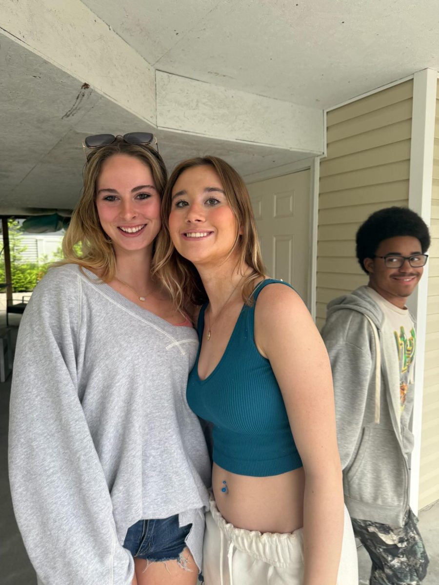 Seniors Caitlin Doherty, Katie Reed, and Daniel Hudson celebrate being done with high school outside of their beach house on their first day of beach week at Bethany Beach.