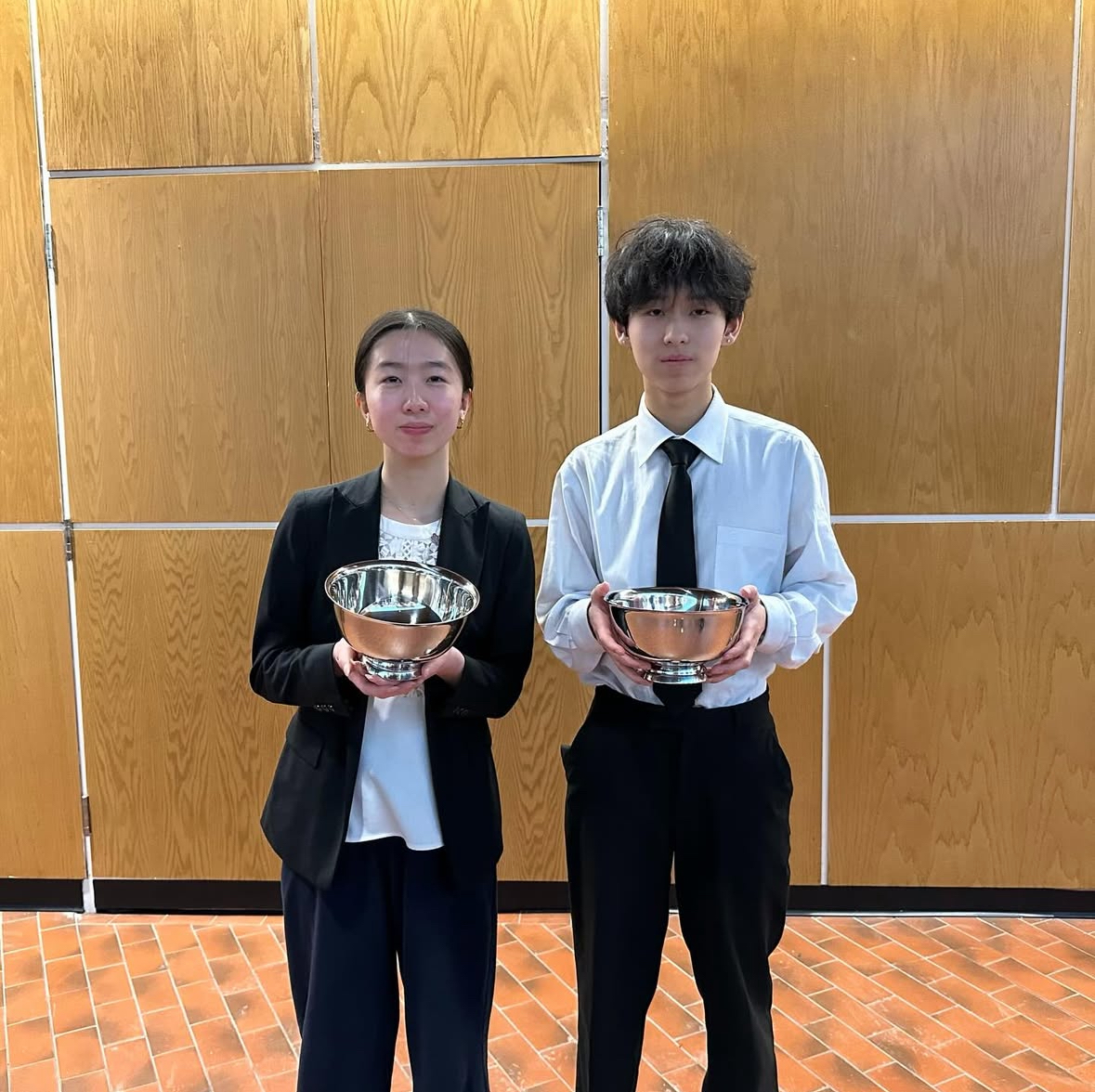 Juniors Isabel Tang and Aaron Tian celebrate after a debate tournament at Harvard in February with their semifinalist trophies. Tian received the competition's fourth-best speaker award. The team finished the tournament, and the season, ranking seventh nationally.