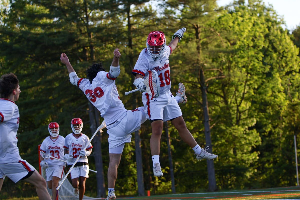 Junior Christos Pazartzis and Benedict Santos celebrate the 11-5 win against Magruder in the regional semi-final on May 9 at home. The team went on to lose to Rockville in the regional final.