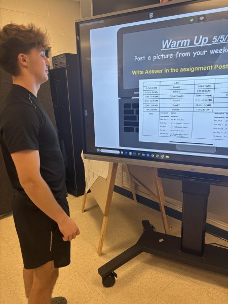 Senior Max Podlesny looks at the schedule for the two weeks of AP testing during his eighth period photography class on May 5.