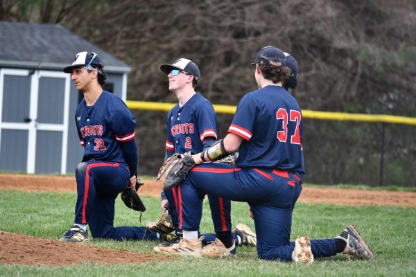 Seniors Jack Kerns and AJ Shifflett and juniors Cyrus Kaz and Josh Reid kneel during their game against Sherwood on Apr. 10.