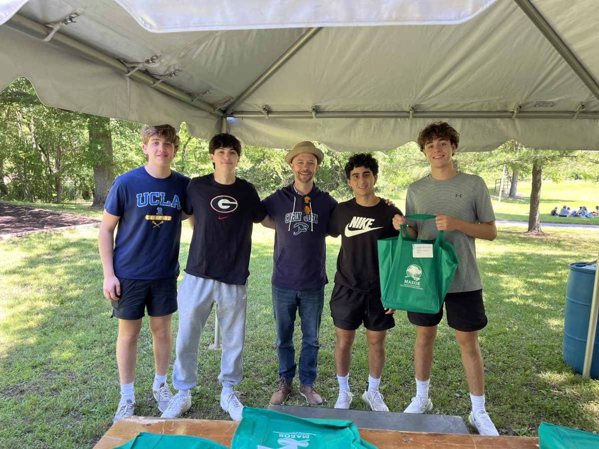 Seniors Max Greenberg, Jake Sklias, Kian Kaz and Toby Subiela receive their Green School Certification award for the club Leading Against Litter from Casey Siddons, assistant principal of Cabin John Middle School.
