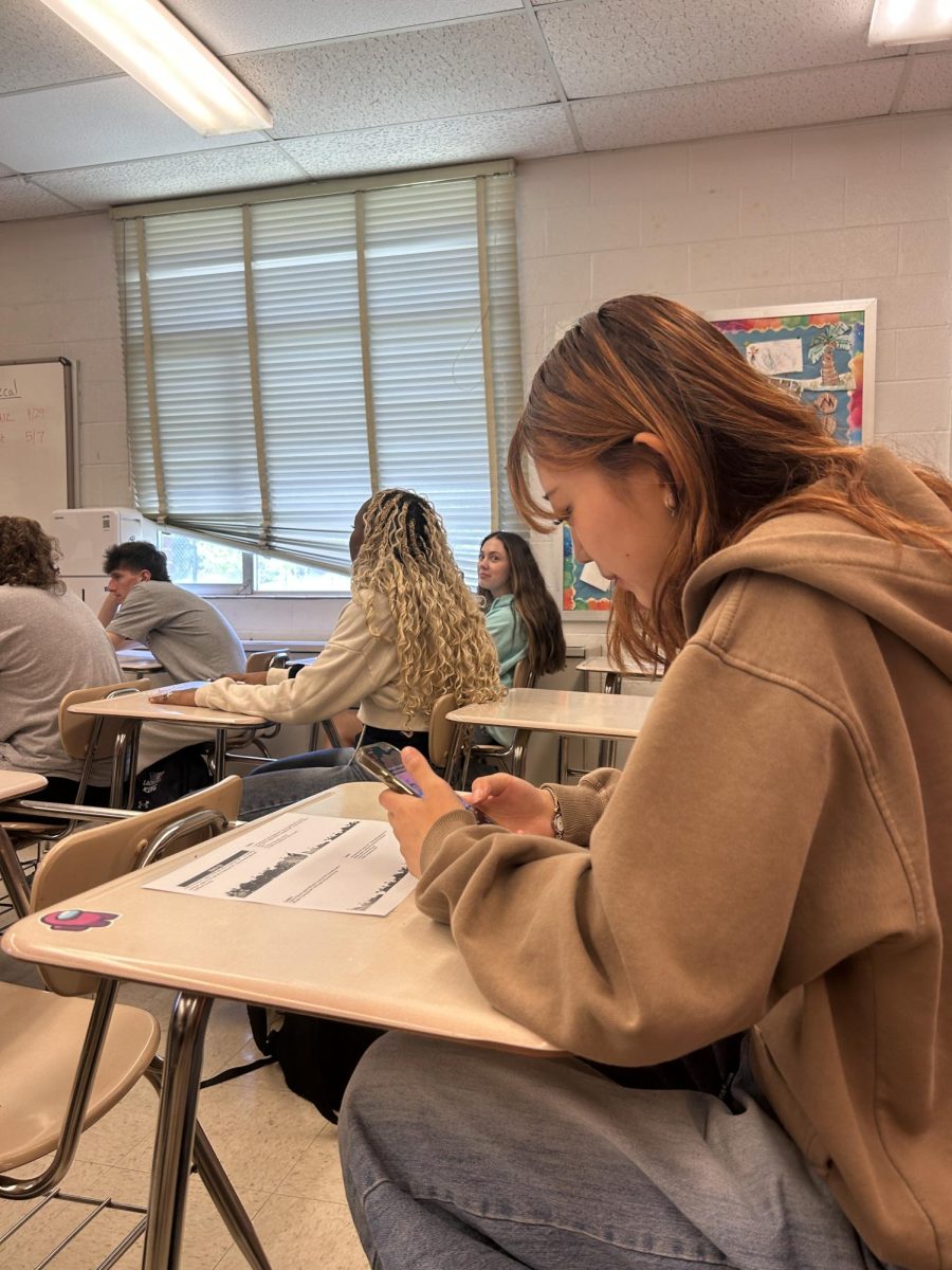 Junior Lina Seo scrolls on her phone during her sixth period precalculus class.