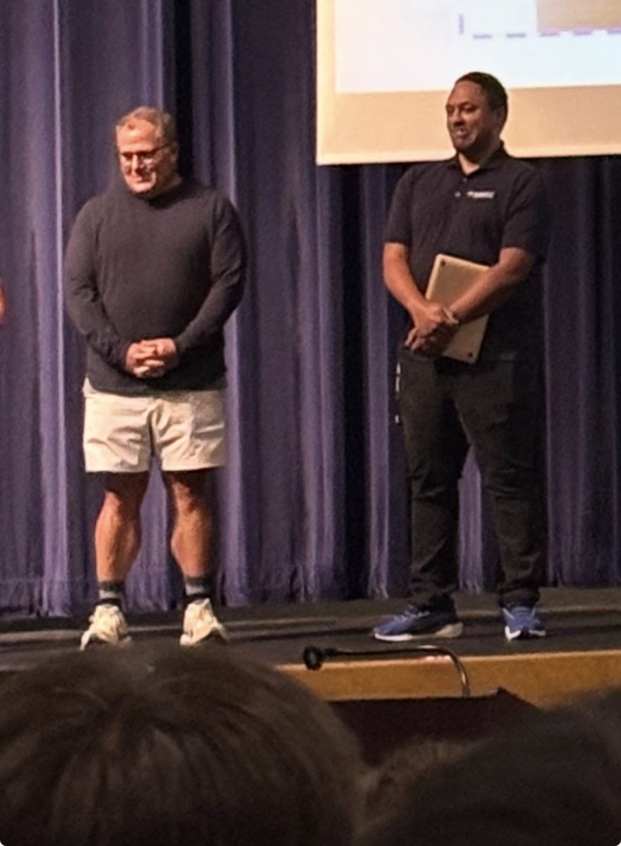 School counselors Robert Kurtz and Angelo Heflin introduce themselves to 11th and 12th grade students at the school's town hall on Sept. 10.