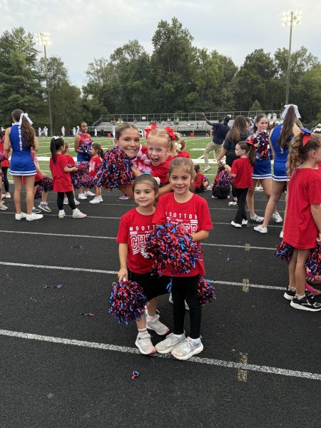 Junior cheerleader Winnie Kelly smiles with Cold Spring Elementary School students who participated in cheer's annual mini camp. "I had a great time and hope they did too," Kelly said. Photo courtesy Joanna Wallace